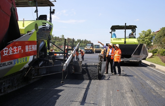 攤鋪機(jī)、壓路機(jī)等設(shè)備緊張有序運(yùn)行，高達(dá)170℃的瀝青混合料炙烤著公路人